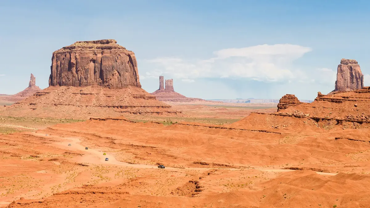 Desert landscape in Monument Valley, Utah with iconic red rock formations and wide open plains under a clear blue sky