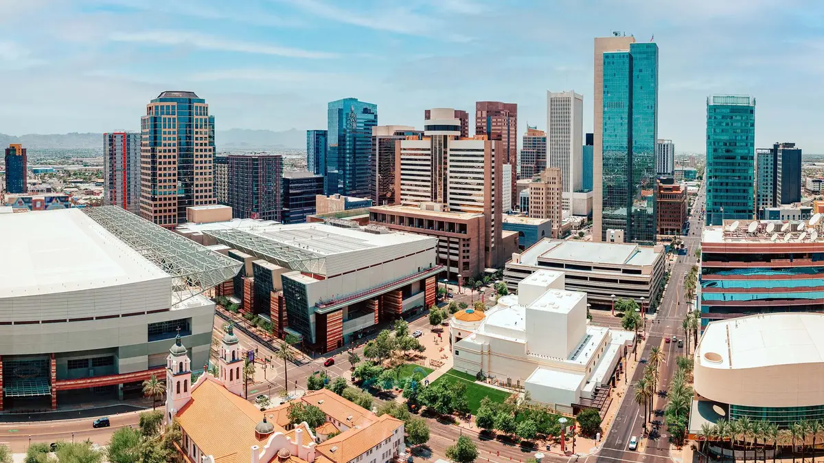 Panoramic view of downtown Phoenix, Arizona with skyscrapers, convention center, and clear view of the surrounding landscape.