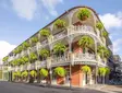 Historic French Quarter building in New Orleans with wrought-iron balconies and hanging plants.
