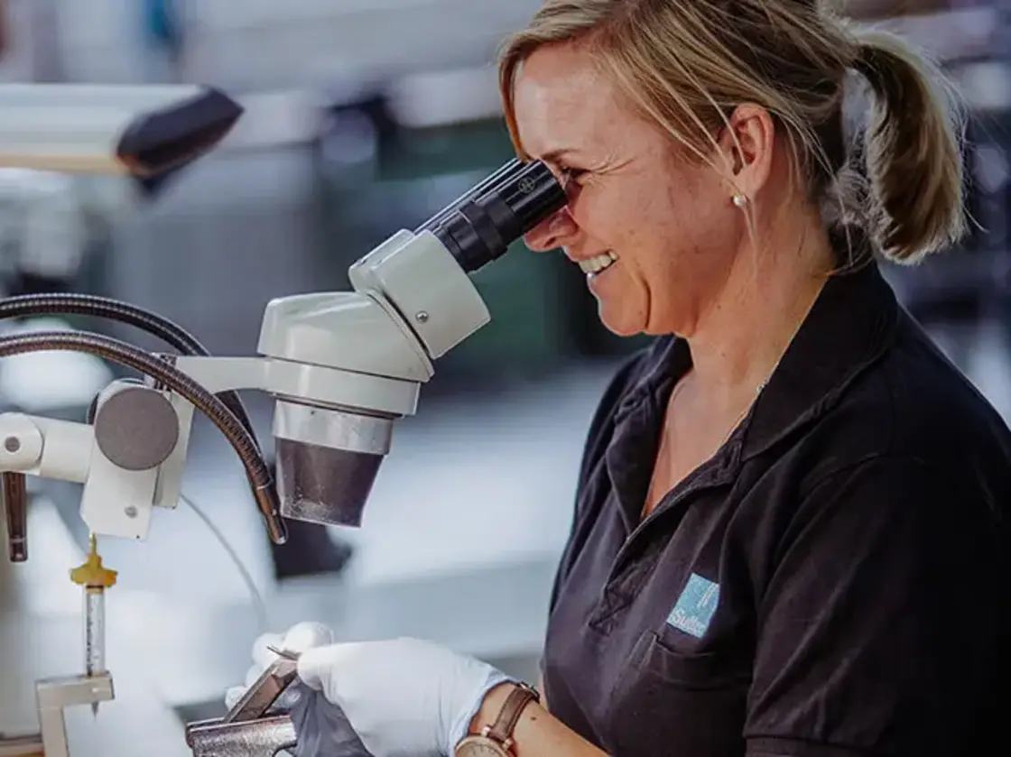 sutter-mitarbeiterin-feinmontage-mikroskop.jpg Mitarbeiterin von Sutter Medizintechnik führt unter dem Mikroskop präzise Montagearbeiten an medizinischen Instrumenten durch