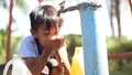 Ein Kind trinkt sauberes Wasser aus einem Wasserhahn – Symbol für das Ziel SDG 6: Zugang zu sicherem Trinkwasser weltweit.