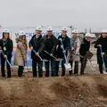 Acht Personen mit weißen Sutter-Bauhelmen und Spaten stehen auf der Baustelle beim offiziellen Spatenstich für das neue Gebäude in Emmendingen.