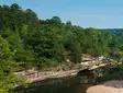 River landscape in the Ozarks with forested hills, rocky shoreline, and calm water
